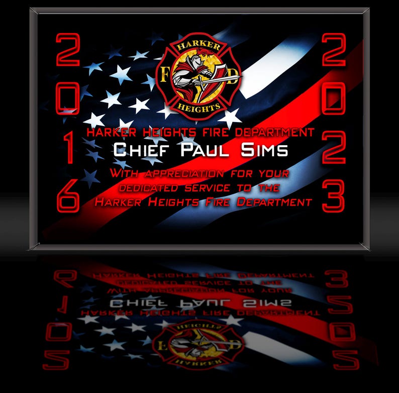 K&ouml;nnte beinhalten: Gerahmte Plakette mit schwarzem Hintergrund, die das Design der amerikanischen Flagge und den Text "Harker Heights Fire Department Chief Paul Sims" zeigt. Die Jahre 2016 und 2023 sind rot dargestellt.