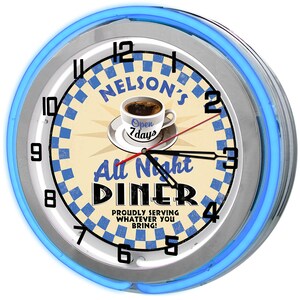 May include: A retro diner clock with a blue neon light border. The clock face features a coffee cup, the words "Nelson's All Night Diner," and a blue and white checkered pattern. The clock shows the time as 2:15.