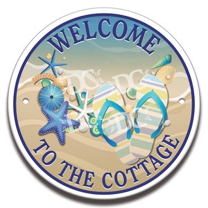 May include: Round welcome sign with blue and white stripes, featuring the text "Welcome to the Cottage" and a beach scene with flip flops, seashells, and starfish.