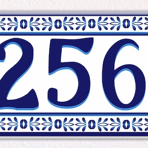 Può includere: Placca per numeri civici in ceramica blu e bianca con il numero 12563 in un carattere decorativo.
