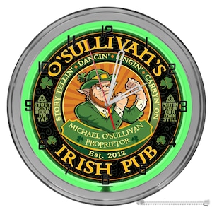 May include: A green neon clock with a silver frame featuring a cartoon leprechaun with the text "O'Sullivan's Irish Pub" and "Story Tellin' Dancin' Singin' Carryin' On". The clock also includes the text "Michael O'Sullivan Proprietor Est. 2012" and "Stout Irish Beer On Tap" and "Poitin From Our Own Still".
