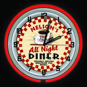 May include: A circular diner clock with a red neon surround. The clock face has a red and white chequered pattern, the words "Nelson's All Night Diner", and a coffee cup. The clock hands indicate the time is 12:06.