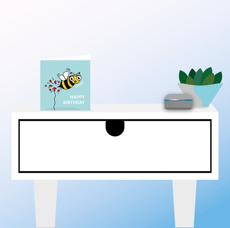 May include: A white dresser with a single drawer and a small, gray speaker on top. A blue card with a cartoon bee and the text "Happy Birthday" is on the left side of the dresser.