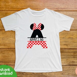 May include: White t-shirt with a black and red Minnie Mouse silhouette and the name "Amelia" printed on it.