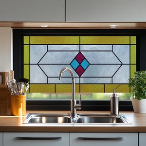 May include: A kitchen sink with a double basin and a chrome tap. The window behind the sink has a stained glass design with a blue and red diamond pattern.