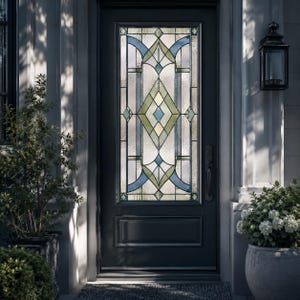 Könnte beinhalten: Eine dunkelgraue Außentür mit einem hohen, rechteckigen Buntglaseinsatz. Das Glas zeigt ein geometrisches Muster mit klaren, strukturierten Scheiben, die durch hellblaue und salbeigrüne Rauten- und Kurvenformen akzentuiert sind.