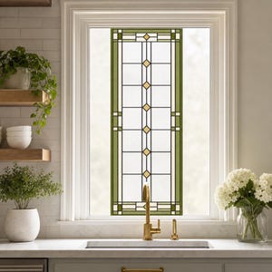 Puede incluir: Una película rectangular para ventana con un patrón de cuadrícula geométrica, bordes verde oliva y pequeños acentos de diamantes amarillos. El diseño consta de paneles rectangulares transparentes separados por finas líneas negras.
