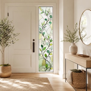 Könnte beinhalten: Ein hoher, rechteckiger Buntglas-Fenstereinsatz mit einem Kletterpflanzenmuster aus grünen Blättern und weißen Beeren. Die Glasscheiben sind in einem fließenden, organischen Design mit verschiedenen Texturen und Grüntönen angeordnet.