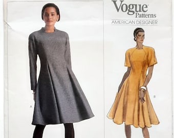 Könnte beinhalten: Vogue American Designer Schnittmuster mit zwei Kleiderdesigns. Eines ist ein langärmeliges, graues, ausgestelltes Kleid. Das andere ist ein kurzärmeliges, gelbes, ausgestelltes Kleid. Das Schnittmuster ist von Geoffrey Beene. Das Muster ist einfach.