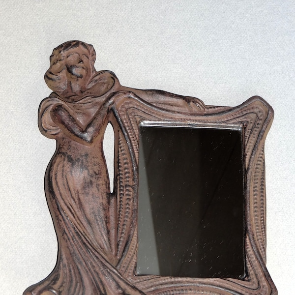 Vintage mirror with frame and Art Nouveau cast iron statue, symbol of femininity, slender silhouette, representation of women, world of art,