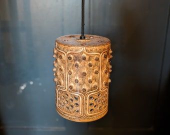 May include: A brown wooden pendant light with a geometric pattern and a black cord.