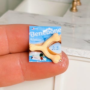May include: Miniature Benebone wishbone dog chew toy on a blue package. The toy is a light tan colour and is shaped like a wishbone. The package has the Benebone logo and the word "wishbone" printed on it.