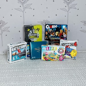 May include: A collection of board games including "Battleship", "Cluedo", "What's That Smell?", "Trivial Pursuit", "The Game of Life", and "Connect 4". The game boxes are various sizes and colors, with colorful graphics and text.