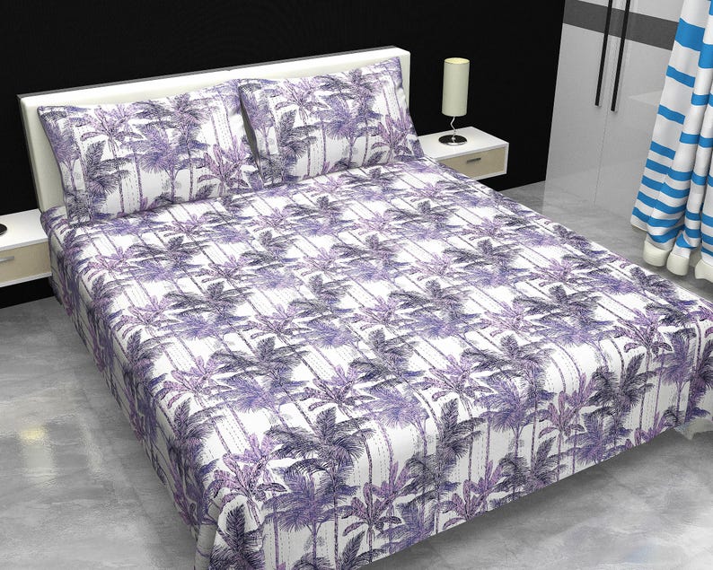 May include: A bed covered with a white sheet and pillowcases featuring a repeating pattern of purple palm trees. The bedding set includes two pillowcases and a fitted sheet. The room has a white headboard and a side table with a lamp.