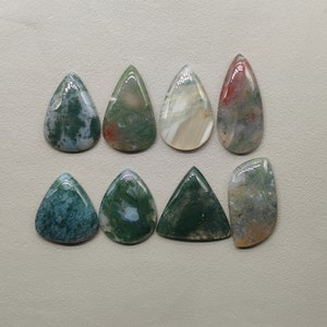 Peut inclure: Huit cabochons en agate en forme de goutte dans différentes nuances de vert, blanc et rouge. Les cabochons sont polis et ont une finition lisse et brillante.