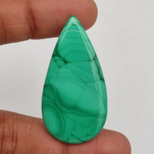 Peut inclure: Une pierre précieuse de malachite verte en forme de larme avec des motifs tourbillonnants.