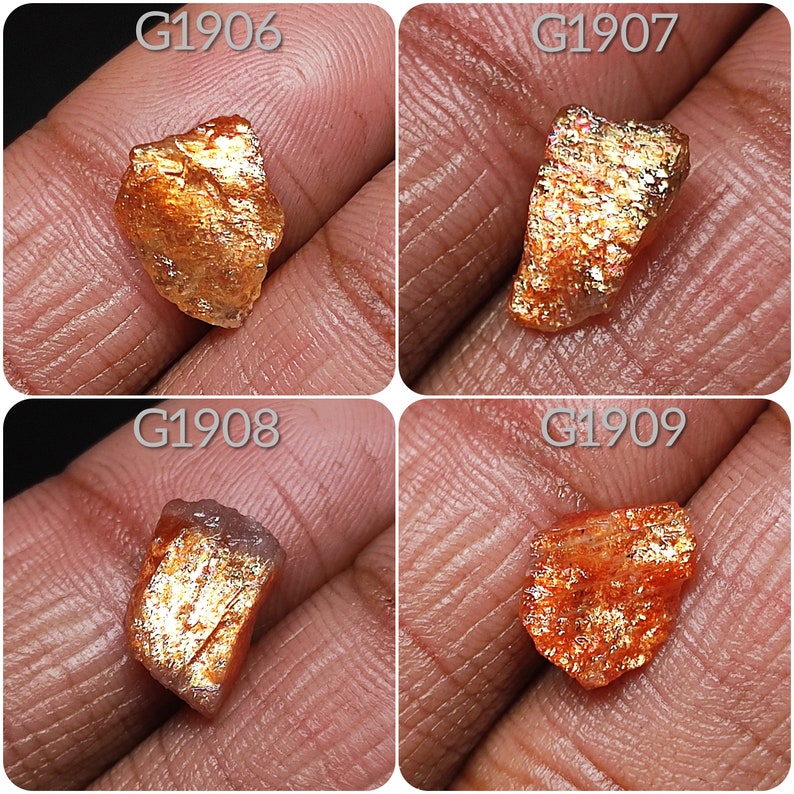 May include: Four rough, raw, orange and gold sunstone crystals with iridescent sparkle. The crystals are labeled G1906, G1907, G1908, and G1909.