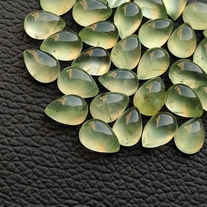 May include: A collection of green teardrop-shaped gemstones, also known as aventurine, with a translucent, glassy finish.