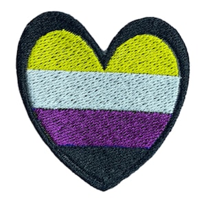 May include: A heart-shaped embroidered patch with the colors of the non-binary pride flag: yellow, white, purple, and black.