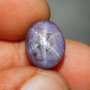 Op de afbeelding: Een paarse ster-saffier cabochon edelsteen met een zespuntige ster.