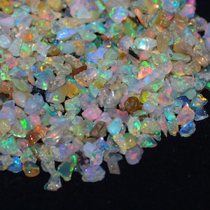 Peut inclure: Un tas de copeaux d'opale irisés de différentes tailles et formes. Les copeaux sont un mélange de blanc, de vert, de bleu et d'orange.