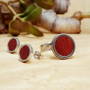 May include: A set of three silver rings with a red wood inlay. The rings are in the shape of a circle and have a smooth, polished finish.