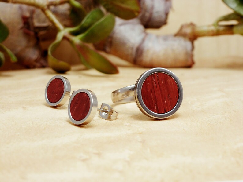 May include: A set of three silver rings with a red wood inlay. The rings are in the shape of a circle and have a smooth, polished finish.