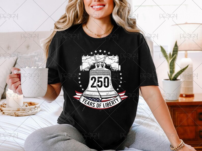 Puede incluir: Camiseta negra con un gr&aacute;fico de la Campana de la Libertad, el n&uacute;mero 250 y el texto "Years of Liberty". El dise&ntilde;o incluye estrellas y una pancarta con la bandera americana.