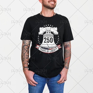 Puede incluir: Camiseta negra con un gr&aacute;fico de la Campana de la Libertad, el n&uacute;mero 250 y el texto "YEARS OF LIBERTY". El dise&ntilde;o incluye una pancarta roja, blanca y azul y un c&iacute;rculo estrellado alrededor de la campana.