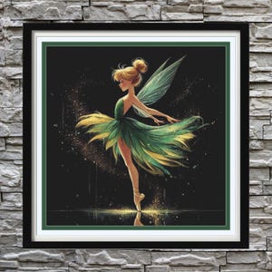 Puede incluir: Una obra de arte enmarcada representa a un hada con un vestido verde y amarillo, con alas a juego, en una pose de ballet. El hada tiene el pelo rubio y está sobre un fondo oscuro con acentos brillantes. El marco es negro con un borde blanco y verde.