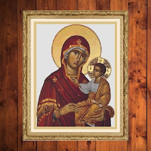 Puede incluir: Un icono religioso que representa a la Virgen María sosteniendo al niño Jesús. El icono está pintado en un estilo tradicional con detalles dorados y un fondo rojo y dorado.