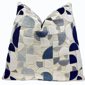 May include: A decorative throw pillow with a geometric pattern of blue and gray semi-circles on a cream background.