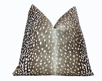 May include: A brown and white patterned throw pillow with a deer print design.