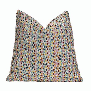 May include: A colorful throw pillow with a gray background and a pattern of small, multi-colored dots.