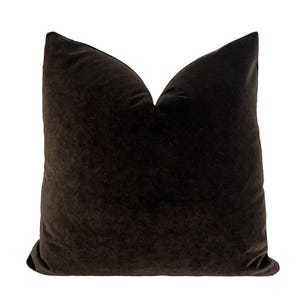 May include: A dark brown velvet pillow with a simple, classic design. The pillow is made of a soft, luxurious fabric and is perfect for adding a touch of elegance to any room.