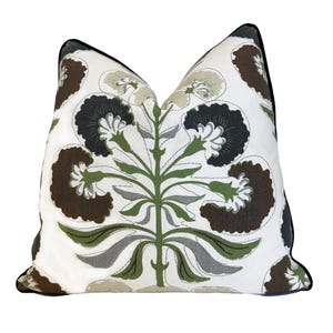 May include: Decorative throw pillow with a white background and a large floral pattern in shades of brown, green, gray, and black. The pillow has a black border.