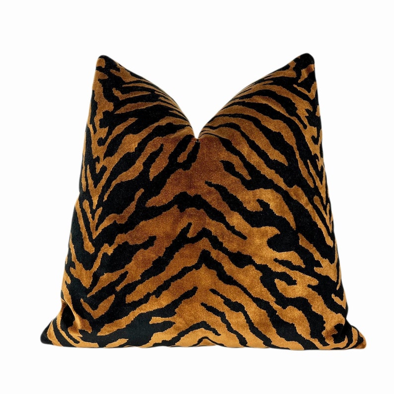 May include: A decorative pillow with a tiger stripe pattern. The pillow features a brown and black design, with the black stripes contrasting against the brown background. The pillow is square and has a soft, plush appearance.