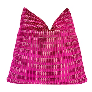 May include: A square throw pillow featuring a vibrant fuchsia pink and cream geometric pattern. The design consists of a repeating grid of small rectangular shapes that create a textured, layered effect across the entire surface of the pillow.