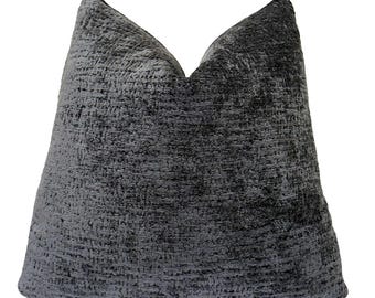 May include: A square throw pillow featuring a dark charcoal gray fabric with a highly textured, nubby, and dimensional surface. The material displays a variegated appearance with subtle shifts in tone, creating a dense, woven, and tactile look.