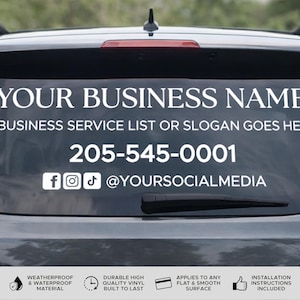 Puede incluir: Una calcomanía de vinilo blanco aplicada a la ventana de un coche. La calcomanía incluye el texto "YOUR BUSINESS NAME", una línea para una lista de servicios comerciales o un eslogan, un número de teléfono y nombres de usuario de redes sociales. La calcomanía es resistente a la intemperie y de vinilo duradero.