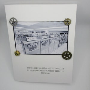 May include: A white card with a black and white image of a room with old computers. The card has four bronze-coloured gear embellishments and binary code text. A retro-themed design.