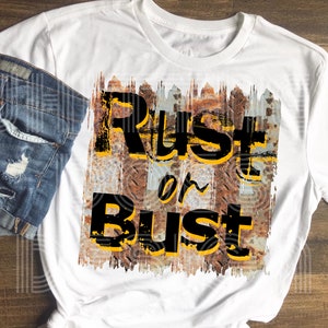 Puede incluir: Camiseta blanca con un fondo de metal oxidado y el texto "Rust or Bust" en letras negras y amarillas.
