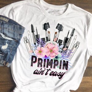 May include: White t-shirt with a graphic design of makeup brushes and flowers. The text "Primpin' ain't easy" is printed below the design.