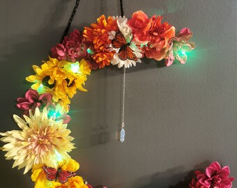 Coroa de flores em forma de lua e borboleta