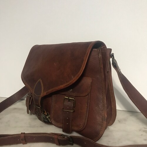 Komals buying cognac leather messenger