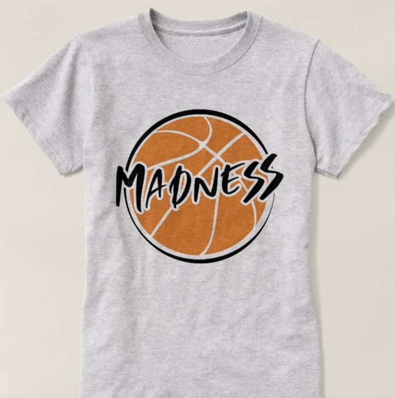 May include: Gray t-shirt with a black and orange basketball graphic and the word "MADNESS" in black.