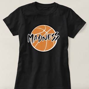 May include: Black t-shirt with an orange basketball graphic and the word "MADNESS" written in black across the basketball.
