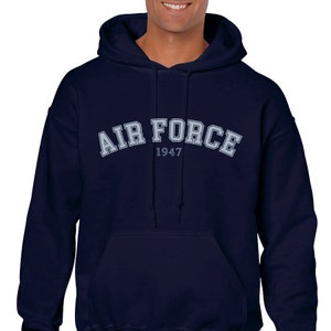 K&ouml;nnte beinhalten: Dunkelblauer Kapuzenpullover mit dem Schriftzug "AIR FORCE 1947" in hellblau.