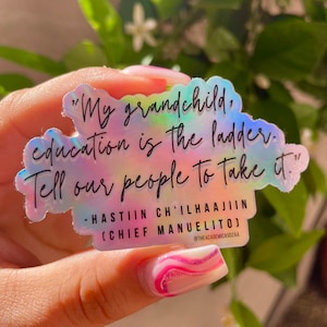 Könnte beinhalten: Ein holografischer Aufkleber mit einem Zitat über Bildung: "Mein Enkelkind, Bildung ist die Leiter. Sag unserem Volk, dass es sie nehmen soll." -Hastiin Ch'ilhaajiiin (Häuptling Manuelito) @theacademicasdzaa