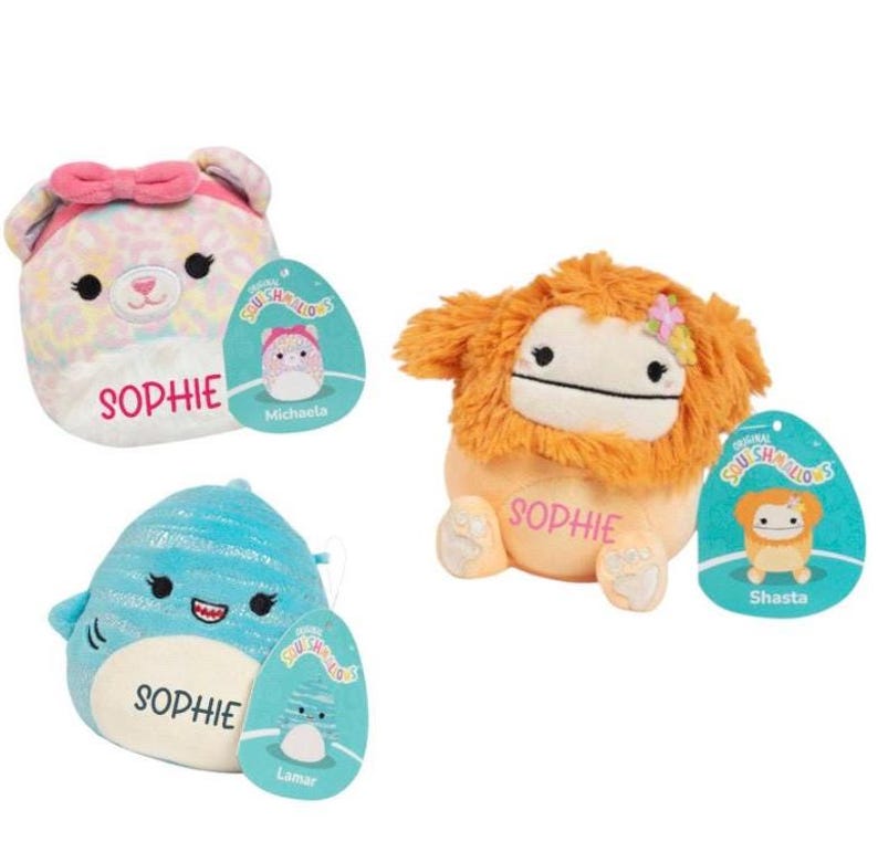 Peut inclure: Trois peluches aux motifs color&eacute;s avec le nom "Sophie" brod&eacute; sur chacune d'elles. Chaque peluche a une &eacute;tiquette avec le nom du personnage et les mots "Original Squishmallows".
